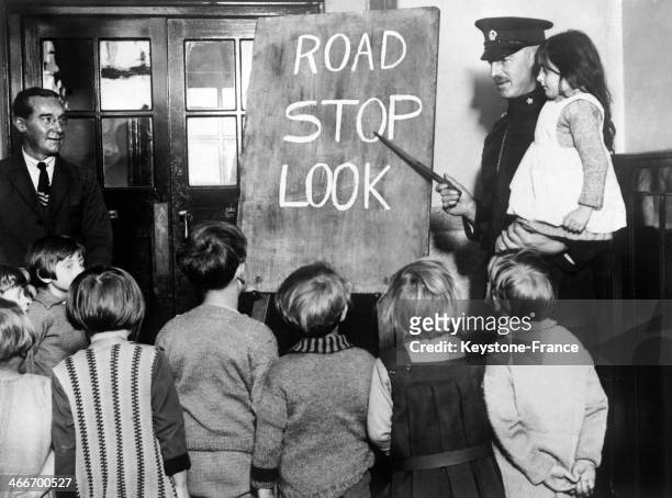 Circa 1920: A policeman is teaching road safety to young schoolchildren, circa 1920 in Southend, United Kingdom.