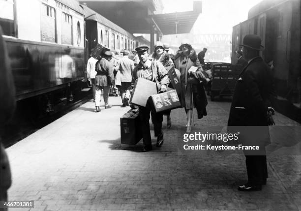Station porter helping two women who got off the train at the station, in May 1929 in Paris, France.