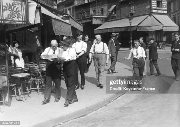 Men strolling in a the street during the heatwave in 1928 in Paris, France.