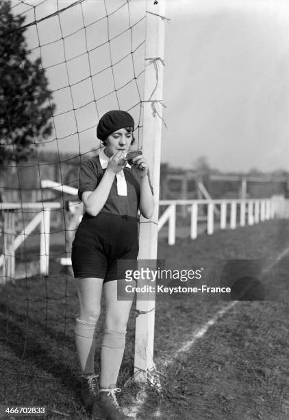 Young female soccer player is checking herself in a pocket mirror before a match in 1929 in France.