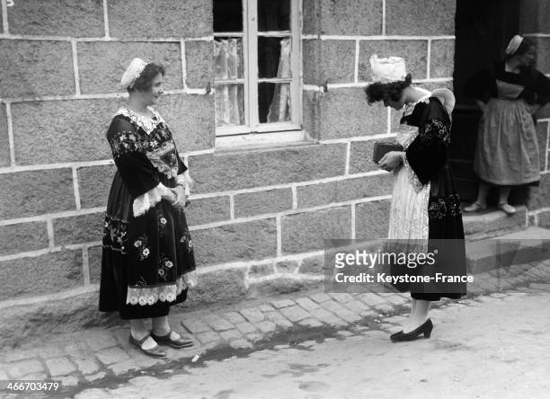 Woman taking picture of a friend wearing a traditional Britton costume during the Celtic festival in August 1929 in Huelgoat, France.