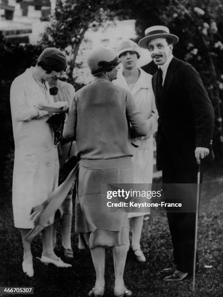 Circa 1930: King of Spain Alfonso XIII and his daughter Infanta Beatriz attend a garden party given by the Duchess of Fernan- Nunez at her residence,...