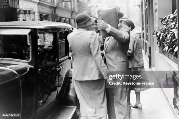 Marlene Dietrich with her manager hides his face behind a disk out of a Hungarian restaurant, in Paris, France.