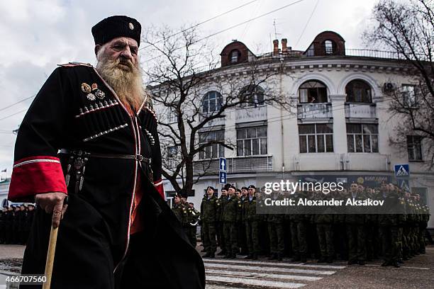 Cossacks march through the streets as people celebrate the first anniversary of the signing of the decree on the annexation of the Crimea by the...
