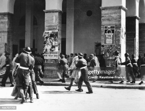 Troops under the command of British Police Officers arresting Libyan people who are protesting, in the Corso Sicilia Street of Tripoli, against the...
