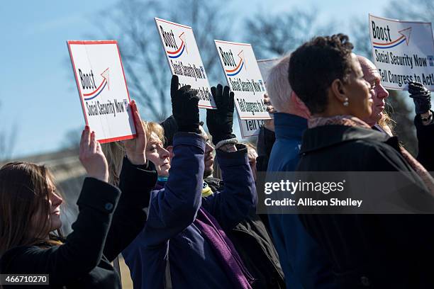 Participants hold up signs as House Democrats hold a news conference to announce the introduction of Social Security 2100 Act in front of the U.S....