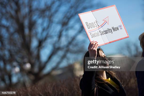 Participant holds up a sign as House Democrats hold a news conference to announce the introduction of Social Security 2100 Act in front of the U.S....