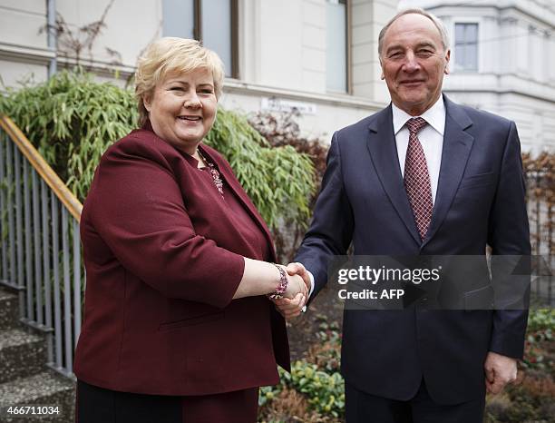 Norwegian Prime Minister Erna Solberg shakes hands with Latvian President Andris Berzins in front of her residence in Oslo, on March 18, 2015. AFP...