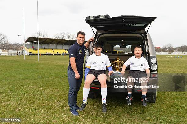 Romeo Gontineac and two young Aurora Baicoi Rugby Club players pose for the camera with the Webb Ellis Cup during Land Rover's Least Driven Path...