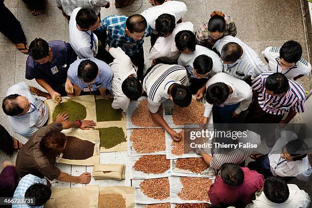 Dealers of beans, cereals and other agricultural products gather for a morning auction at the Mandalay Brokers, traders and millers association.