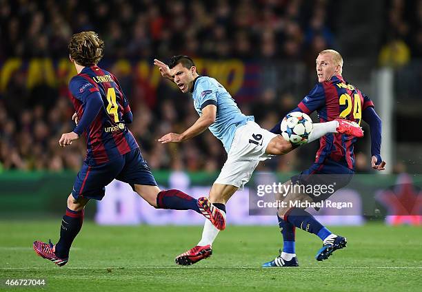 Sergio Aguero of Manchester City is challenged by Jeremy Mathieu and Ivan Rakitic of Barcelona during the UEFA Champions League Round of 16 second...