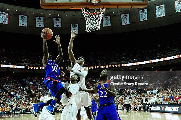 Naadir Tharpe of the Kansas Jayhawks is defended by Jonathan Holmes and Isaiah Taylor of the Texas Longhorns during a game at The Frank Erwin Center...