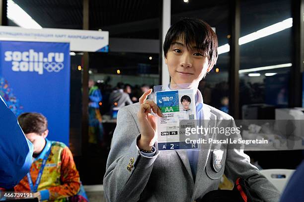 Men's figure skater Yuzuru Hanyu of Japan shows his accreditation as he arrives at Sochi International Airport ahead of the Sochi 2014 Winter...