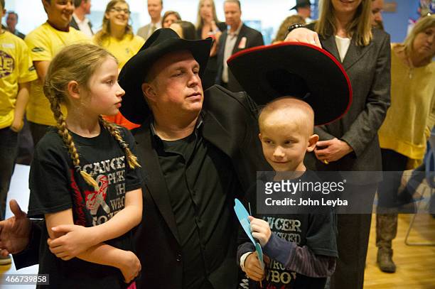 Garth Brooks fixes Levi Foreman 6 years old, cowboy hat for a photo op with his sister Abigail Foreman 9 years old at Childrens Hospital to Celebrate...