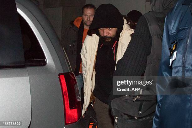 French comedian Dieudonne M'bala M'bala is flanked by security guards as he leaves the Theater of Marens after his performance on February 3, 2014 in...