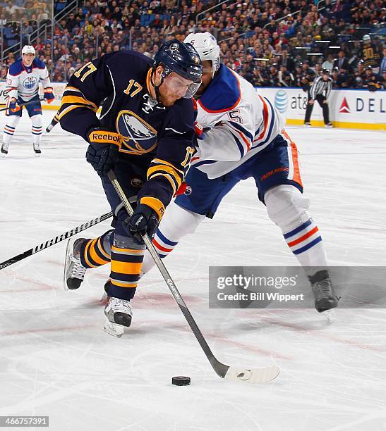 Linus Omark of the Buffalo Sabres an Mark Fraser of the Edmonton Oilers battle for the puck on February 3, 2014 at the First Niagara Center in...