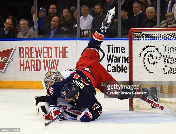 Rick Nash of the New York Rangers gets tripped up on Scott Darling of the Chicago Blackhawks during the first period at Madison Square Garden on...