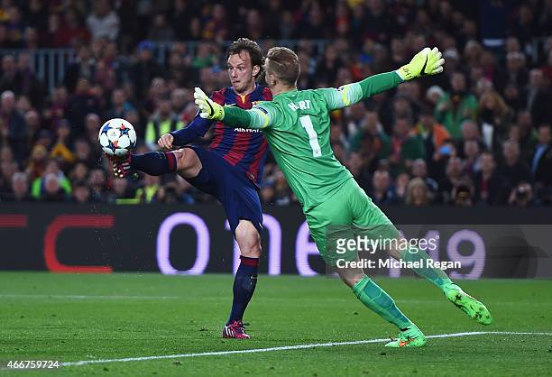 Ivan Rakitic of Barcelona lifts the ball over Joe Hart of Manchester City to score the opening goal during the UEFA Champions League Round of 16...