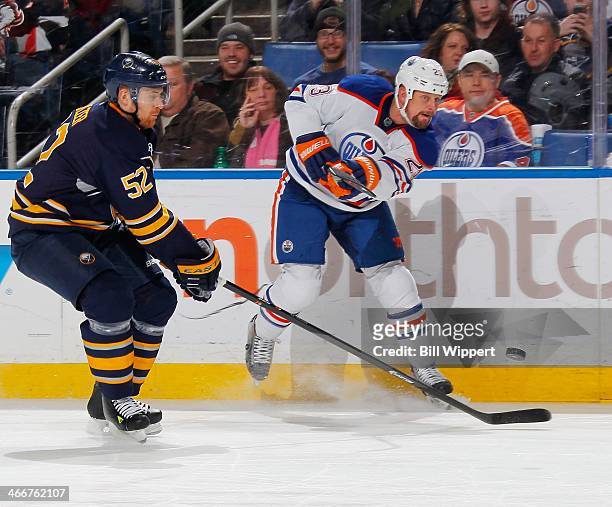 Matt Hendricks of the Edmonton Oilers shoots the puck against Alexander Sulzer of the Buffalo Sabres on February 3, 2014 at the First Niagara Center...