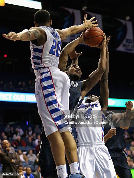 Vauntes Smith-Rivera of the Georgetown Hoyas puts up a shot between Brandon Young and Edwind McGhee of the DePaul Blue Demons at the Allstate Arena...