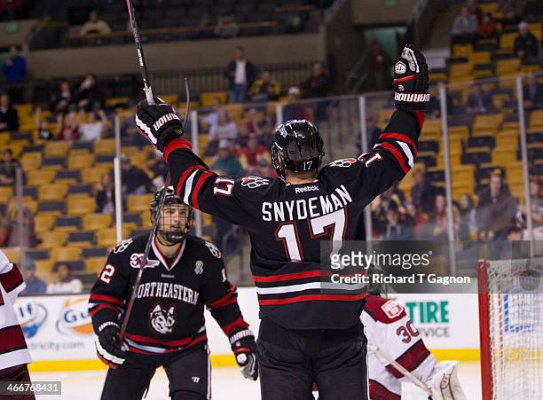 Torin Snydeman of the Northeastern University Huskies celebrates scoring on Raphael Girard of the Harvard Crimson during NCAA hockey action in the...