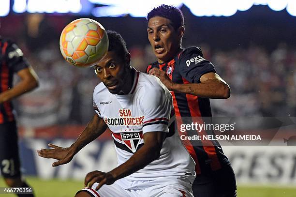 Michel Bastos of Brazil's Sao Paulo vies for the ball with Pablo Barrientos of Argentina's San Lorenzo during their 2015 Copa Libertadores football...