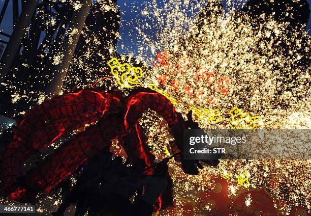 This picture taken on February 3, 2014 shows a dragon dance troupe performing with fireworks during a Lunar New Year celebration in Beijing....