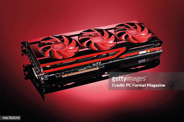An AMD Radeon HD7990 dual-GPU graphics card photographed on a red background, taken on April 29, 2013.