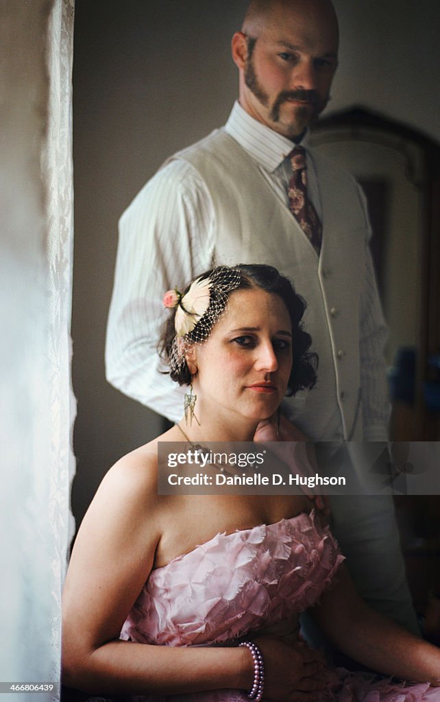 Bride and groom posing at window