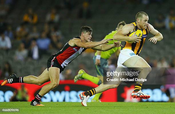 Jarryd Roughead of the Hawks runs with the ball past Jack Sinclair of the Saints during the NAB Challenge AFL match between St Kilda Saints and...