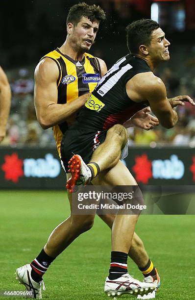 Ben Stratton of the Hawks kicks the ball from Darren Minchington of the Saints during the NAB Challenge AFL match between St Kilda Saints and...