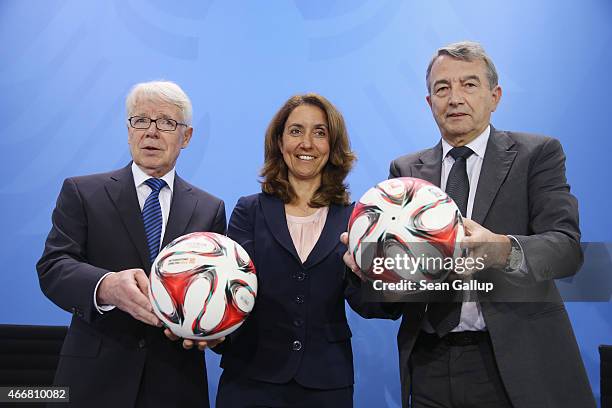 President Reinhard Rauball, German Integration Commissioner Aydan Ozoguz and DFB President Wolfgang Niersbach hold soccer balls as they arrive for a...