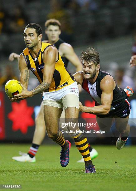 Shaun Burgoyne of the Hawks handballs awau from Josh Bruce of the Saints during the NAB Challenge AFL match between St Kilda Saints and Hawthorn...