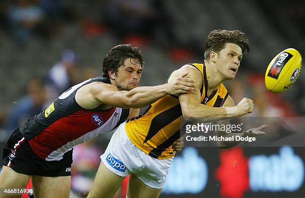Taylor Duryea of the Hawks handballs away from Cameron Shenton of the Saints during the NAB Challenge AFL match between St Kilda Saints and Hawthorn...