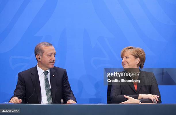 Recep Tayyip Erdogan, Turkey's prime minister, left, reacts beside Angela Merkel, Germany's chancellor, during a news conference at the Chancellery...