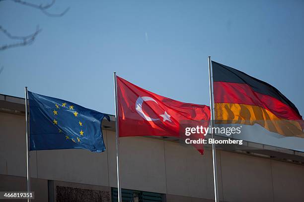 The European Union flag, left, flies beside a Turkish national flag, center, and a German national flag outside the Chancellery in Berlin, Germany,...