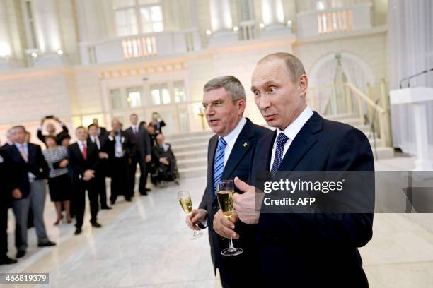 Russian President Vladimir Putin and International Olympic Committee President Thomas Bach greet IOC members at a welcoming event ahead of the 2014...
