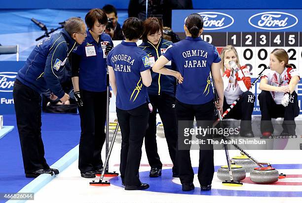 Members of Japan discuss at the 8th end during a round-robin match between Japan and Canada during day six of the World Women's Curling Championship...