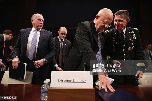 Director of National Intelligence James Clapper listens to Lt. Gen. Michael Flynn as Central Intelligence Agency Director John Brennan about to leave...