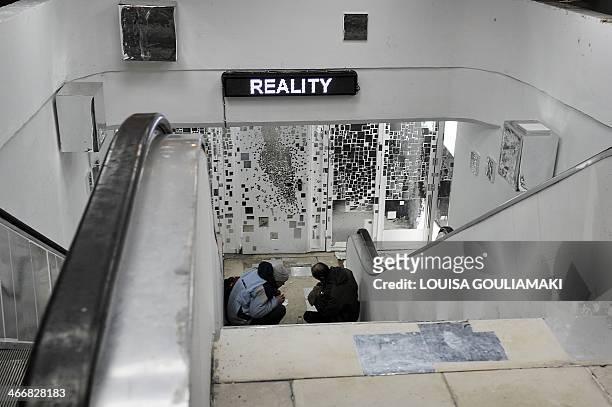 Intravenous drug users prepare to inject doses in an unused passageway of the Athens subway which was recently transformed by artists of the city, on...