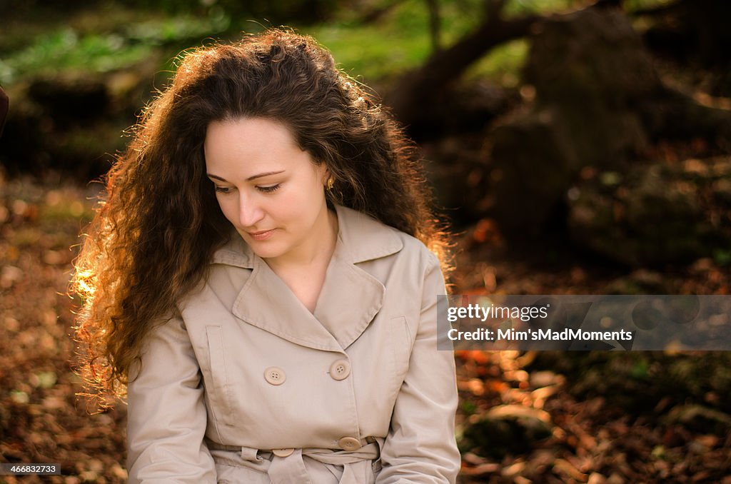 Beautiful woman with curly hair in the forest