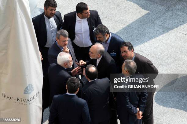 Iran's Foreign Minister Mohammad Javad Zarif and head of the Atomic Energy Organization of Iran Ali Akbar Salehi talk outside with aides after a...