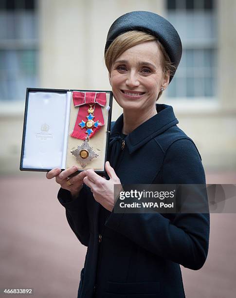 Dame Kristin Scott Thomas holding her Dame Commander of the British Empire medal presented to her by Queen Elizabeth II at Buckingham Palace on March...