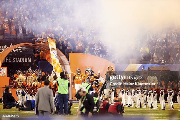 Super Bowl XLVIII: Ann Judge-Wegener riding on Denver Broncos mascot Thunder, leading team onto field before game vs Seattle Seahawks at MetLife...