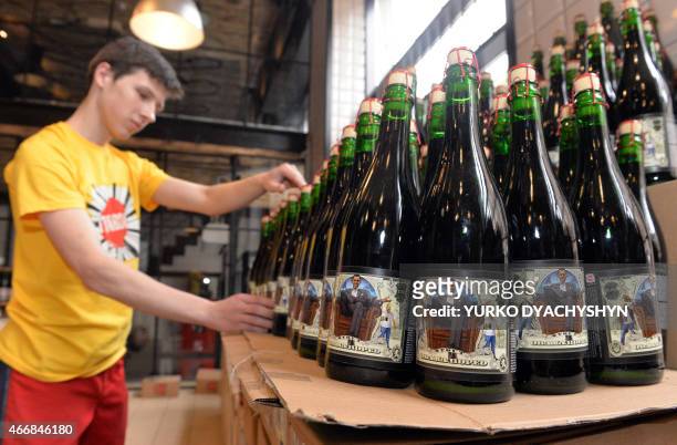 An employee at the Beer Theater, a restaurant in the western Ukrainian city of Lviv, arranges on March 19, 2015 bottles of Obama Hoped stout brewed...