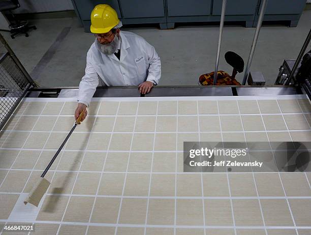 Isaac Lieberman, a Mashgiach, or rabbinical supervisor, removes a flawed sheet of unbaked matzo as they travel on the matzo production line at the...