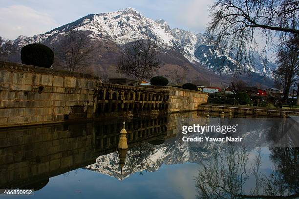 Snow capped Zabarvan mountains are reflected in the Shalimar Mughal garden fountains on March 19, 2015 in Srinagar, the summer capital of Indian...