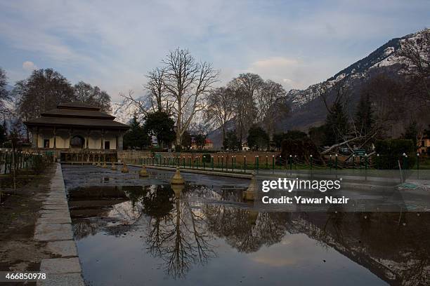 Snow capped Zabarvan mountains are reflected in the Shalimar Mughal garden fountains on March 19, 2015 in Srinagar, the summer capital of Indian...