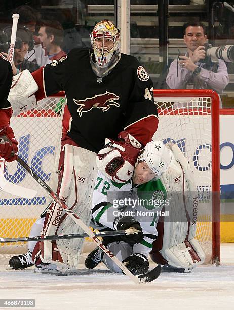 Erik Cole of the Dallas Stars and goaltender Mike Smith of the Phoenix Coyotes get tangled in front of the net during the second period at Jobing.com...