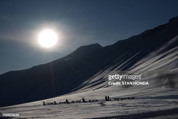 Eclipse watching tourists ride dog sleds outside of Longyearbyen, Svalbard, an archipeligo administered by Norway on March 19, 2015 ahead of the...